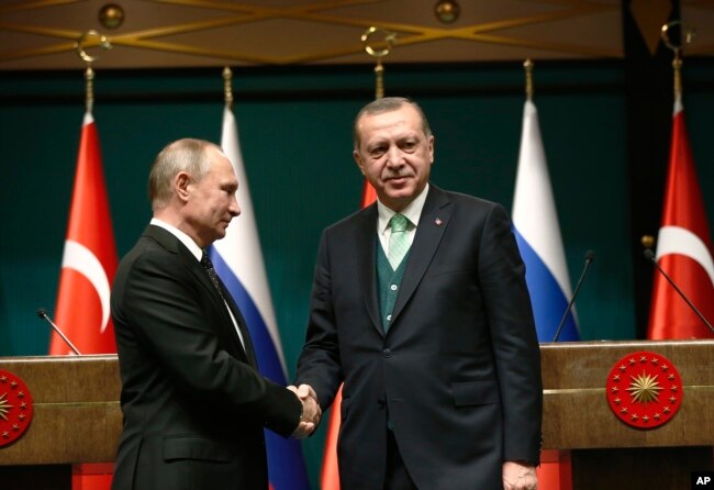 FILE - Turkey's President Recep Tayyip Erdogan, right, shakes hands with Russia's President Vladimir Putin following their joint news statement after their meeting at the Presidential Palace in Ankara, Turkey, Dec. 11, 2017.