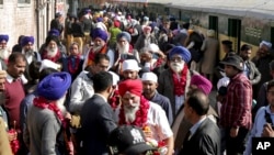 Indian Sikh pilgrims arrive at Wagha railway station to attend the birth anniversary of their spiritual leader Baba Guru Nanak, in Pakistan, Wednesday, Nov. 21, 2018.