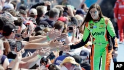 FILE - In this Feb. 22, 2015, file photo, driver Danica Patrick greets fans as she is introduced before the start of the Daytona 500 NASCAR Sprint Cup series auto race at Daytona International Speedway in Daytona Beach, Fla.