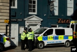 FILE - Police officers stand outside a Zizzi restaurant in Salisbury, England, March 7, 2018, near to where former Russian double agent Sergei Skripal was found critically ill.