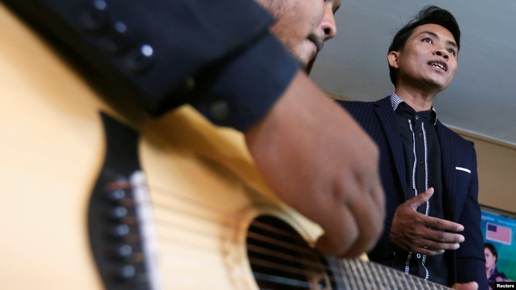 Yorn Young (R) sings before a news conference in Phnom Penh, Cambodia, March 6, 2018. Picture taken on March 6, 2018. REUTERS/Samrang Pring