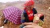 FILE - A woman holds her child as she waits while rescuers search for her husband, a victim of a landslide in Vietnam's northern province of Yen Bai on September 8, 2012.