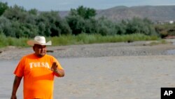 FILE - Navajo Nation Council Delegate Davis Filfred walks along the San Juan River, Aug. 11, 2015, in Montezuma Creek, Utah. 