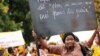 A woman at a pro-Alpha Condé rally in the Guinea capital Conakry, September 29, 2012. The sign reads: 'Papa Alpha Condé says no to violence, yes to peace'. (N. Palus for VOA)