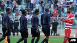 Le capitaine tunisien Zouheir Dhaoudi (L) s'entretient avec l'arbitre éthiopien Bazezew Belete (CR) qui a déclaré Club Africain vainqueur du match de football de la Coupe de la confédération contre l'équipe nigériane Dolphin Port Harcourt au stade de Radè