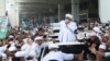 Indonesian Islamic cleric and the leader of Islamic Defenders Front Rizieq Shihab, center, speaks to his followers upon arrival from Saudi Arabia at Soekarno-Hatta International Airport in Tangerang, Indonesia, Tuesday, Nov. 10, 2020. Thousands of…