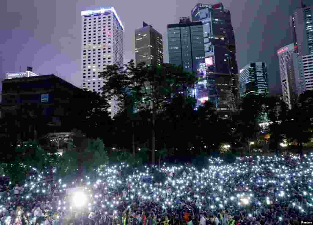 Attendees hold up their lit mobile phones during a rally by civil servants to support the anti-extradition bill protest in Hong Kong, China.
