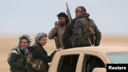 FILE - Syrian Democratic Forces fighters ride on a vehicle near Raqqa, Feb. 5, 2017. The U.S.-backed troops have made significant advances.