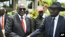 South Sudan's First Vice President Riek Machar, left, and President Salva Kiir shake hands following the first meeting of a new transitional coalition government, in the capital, Juba, April 29, 2016. 