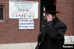 FILE PHOTO: A sign warning people of measles in the ultra-Orthodox Jewish community of Williamsburg in New York City, April 11, 2019.