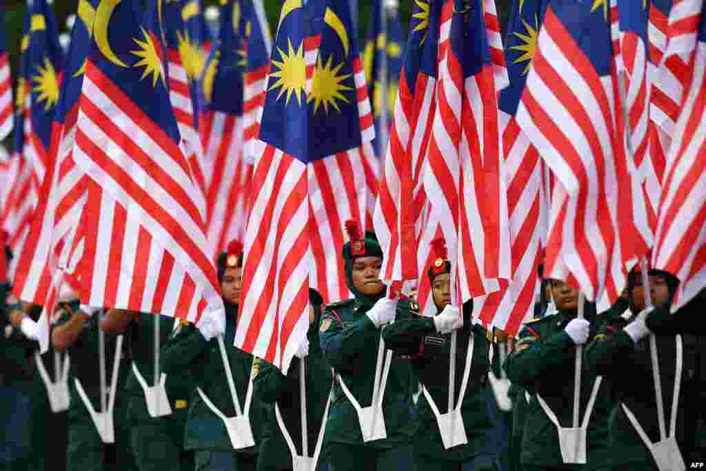 Malaysian school cadets carry national flags during the National Day celebration parade in Putrajaya, on the outskirts of Kuala Lumpur.