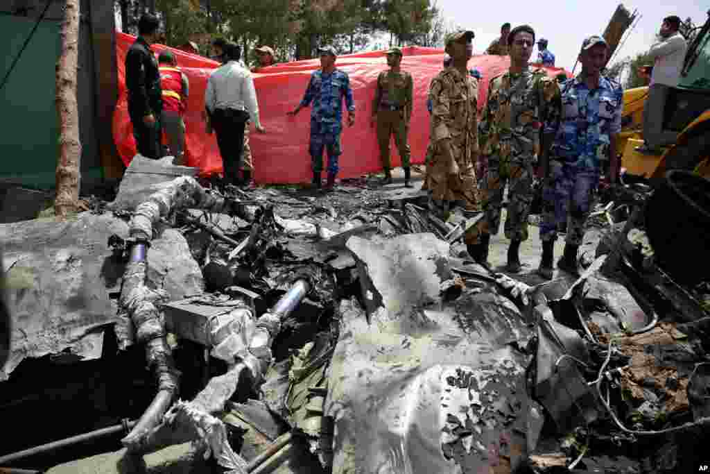 Iranian security and rescue personnel work the site of a passenger plane crash near the capital Tehran, Iran, Aug. 10, 2014. 