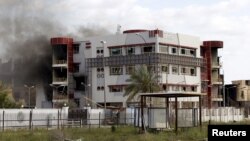 Smoke is seen coming from behind a building in Tikrit, April 1, 2015. 