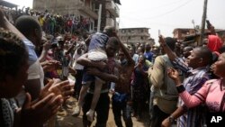 Para petugas penyelamat berhasil mengevakuasi salah seorang anak yang terperangkap dalam bangunan runtuh di Lagos, Nigeria, Rabu (13/3). 