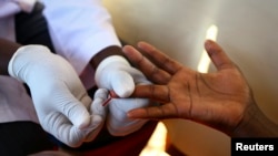 FILE - A doctor draws blood from a man to check for HIV/AIDS.