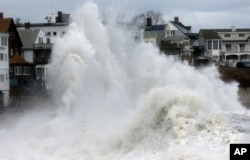 A large wave crashes into a seawall in Winthrop, Massachusetts, March 3, 2018, a day after a nor'easter pounded the Atlantic coast.