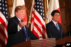 FILE - President Donald Trump, left, speaks as Japanese Prime Minister Shinzo Abe looks on during a joint news conference at the Akasaka Palace in Tokyo, Nov. 6, 2017.