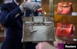 An employee holds an Hermes diamond and Himalayan Nilo Crocodile Birkin handbag at Heritage Auctions offices in Beverly Hills, California September 22, 2014.