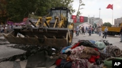 工作人員在清理伊斯坦布爾一個廣場抗議人士遺留下來的雜物。
