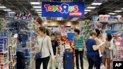 FILE - Shoppers browse at a Toys R Us store in Miami, Nov. 25, 2016. The toys your kids unwrap this Christmas could invite hackers into your home. That Grinch-like warning comes from the FBI, which said this summer that toys connected to the internet could be a target for crooks who may listen in on conversations or use them to steal a child’s personal information. 