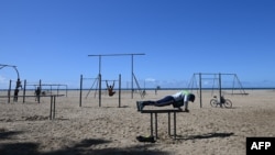 人们在加州圣塔莫妮卡肌肉海滩在保持距离的情况下锻炼身体。(2020年3月23日)