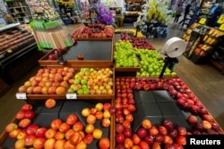 FILE - Apples are displayed for sale at the produce area as customers browse grocery store shelves inside Kroger Co.'s Ralphs supermarket in Los Angeles, California, U.S. March 15, 2020. REUTERS