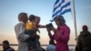 Refugees check their mobiles aboard a ferry traveling from the northeastern Greek island of Lesbos to the Athens&#39; port of Piraeus, Sept. 10, 2015. (AP)