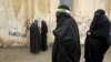 FILE - Veiled Iranian women take part in a mourning ceremony, as they cover their faces symbolically, in the city of Khorramabad, southwest of Tehran.