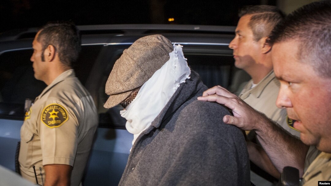 Nakoula Basseley Nakoula (tengah) dikawal keluar dari rumahnya oleh petugas berwenang di Los Angeles (15/9). (Reuters)