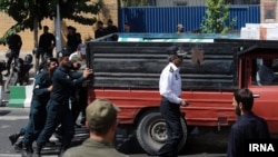 ماموران نیروی انتظامی در حال هل دادن یک وانت در مقابل سفارت بریتانیا