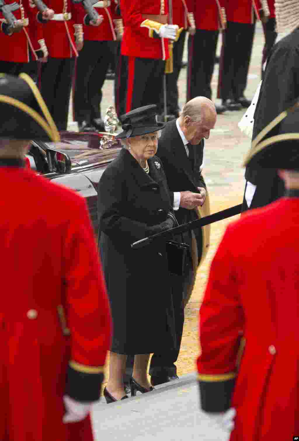 Britain's Queen Elizabeth II, center left, and her husband Prince Philip, the Duke of Edinburgh, arrive for the funeral of former British Prime Minister Margaret Thatcher, outside St. Paul's Cathedral, central London, Wednesday, April 17, 2013. A coffin c