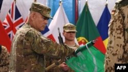 Tướng John Campbell (trái) cuộn lá cờ của lực lượng ISAF trong buổi lễ đánh dấu sự kết thúc sứ mệnh tác chiến ở Afghanistan, 28/12/2014.