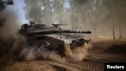 Tank Israel melakukan manuver setelah gencatan senjata lima jam berakhir dekat perbatasan Gaza (17/7).