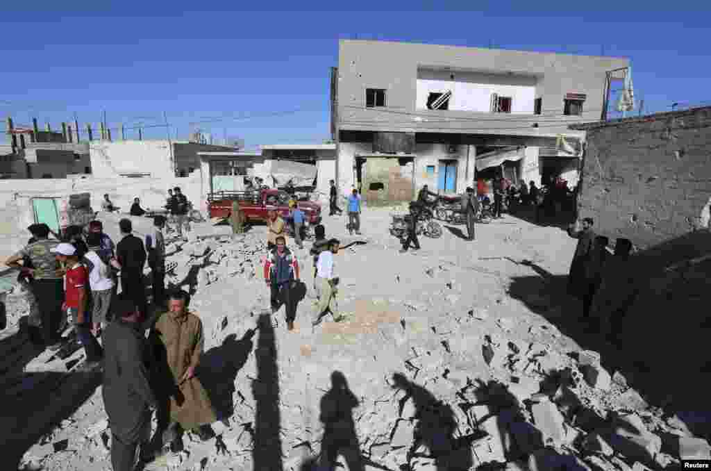 People inspect a site hit by what activists said were barrel bombs dropped by forces loyal to President Bashar al-Assad, in al-Letmana village, Hama province, May 1, 2014.&nbsp;