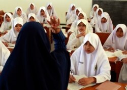 A teacher gestures during an Islam personality class during the holy month of Ramadan at the Al-Mukmin Islamic boarding school in Solo, Indonesia Central Java province, Aug. 2, 2011.