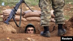 A Turkish soldier takes up position near the Syrian border in the Turkish town of Ceylanpinar, Sanliurfa province, November 30, 2012.