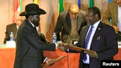 Days after signing a power-sharing deal with South Sudan President Salva Kiir (left), rebel chief Riek Machar (right) says there is still "a long way to go" before peace is restored.