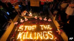 FILE - Human rights activists light candles for the victims of extrajudicial killings around the country in the wake of the War on Drugs campaign by Philippine President Rodrigo Duterte in suburban Quezon city northeast of Manila, Philippines, Aug. 15, 2016.