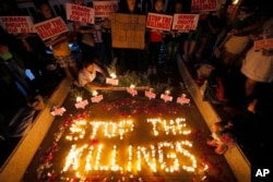 FILE - Human rights activists light candles for the victims of extra-judicial killings around the Philippines in the wake of a "War on Drugs" campaign initiated by Philippine President Duterte, in suburban Quezon city northeast of Manila, Philippines. Duterte's anti-drug policy has drawn international criticism.