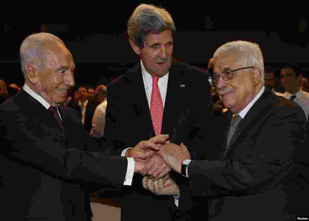 U.S. Secretary of State John Kerry (C) shakes hands with Israeli President Shimon Peres (L) and Palestinian President Mahmoud Abbas at the World Economic Forum at the King Hussein Convention Center, at the Dead Sea, Jordan.
