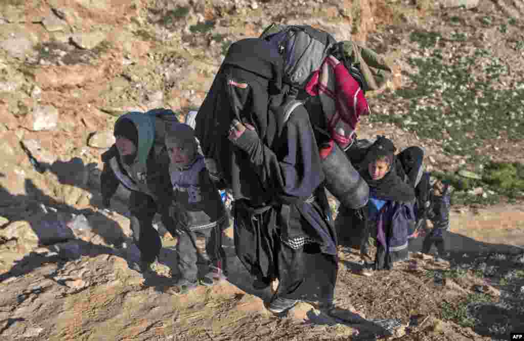 Civilians flee from the Baghuz area in the eastern Syrian province of Deir el-Zour, Feb. 12, 2019, during an operation by the U.S.-backed Syrian Democratic Forces (SDF) to expel hundreds of Islamic State group (IS) jihadists from the region.