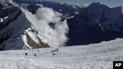 Para anggota tim SAR berusaha mencari korban hilang di antara reruntuhan salju longsor di Gunung Manaslu, Nepal utara (23/9). 