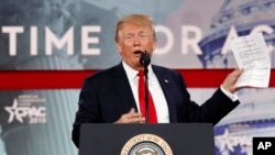 President Donald Trump holds up his notes as he reads the lyrics to “The Snake,” a ballad by Al Wilson about a reptile, while addressing the Conservative Political Action Conference, at National Harbor, Maryland, Feb. 23, 2018. 