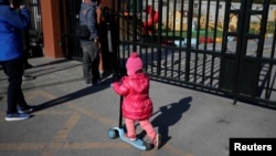 A child plays outside the kindergarten run by preschool operator RYB Education Inc being investigated by China's police, in Beijing, China, Nov. 24, 2017.