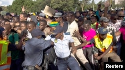 La police tente de contrôler la foule voulant voir le corps de Mandela à Pretoria le 13 décembre 2013 (Reuters/Ronen Zvulun).