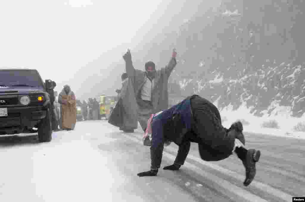 People play with snow after a heavy snowstorm in the desert near Tabuk, 1500 km (932 miles) from Riyadh, Saudi Arabia. 