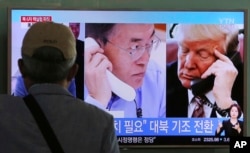 A man watches a TV screen showing U.S. President Donald Trump, right, and South Korean President Moon Jae-in during a news program at the Seoul Railway Station in South Korea, Sept. 5, 2017.