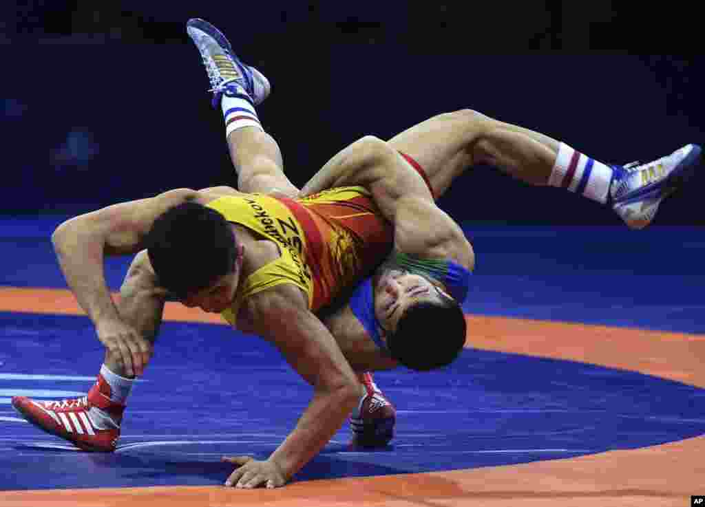 Eldaniz Azizli of Azerbaijan, right, battles Zholaman Sharshenbekov of Kyrgyzstan, left, in the Greco-Roman 55kg category of the Wrestling World Championships in Budapest.