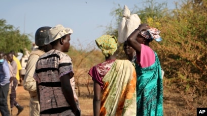 DOSSIER - Des femmes et des filles s’adressent à des membres d’une patrouille de maintien de la paix de l’ONU alors qu’ils marchent chercher de la nourriture à Bentiu, craignant d’être attaqués en chemin, près de Nhialdu, au Soudan du Sud, le 7 décembre 2018.