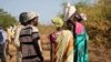 FILE - Women and girls speak to members of a U.N. peacekeeping patrol as they walk to get food in Bentiu, fearful of being attacked on the way, near Nhialdu, South Sudan, Dec. 7, 2018.